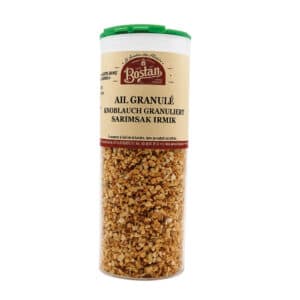 Glass jar of garlic granules with green lid, labeled in multiple languages for seasoning use