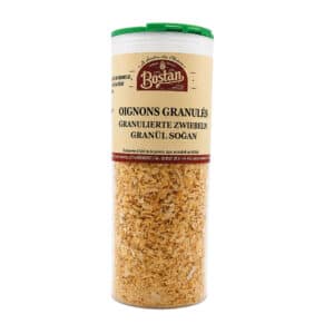 Tall clear spice container filled with golden onion granules and a green lid, labeled in multiple languages (onions granulated).
