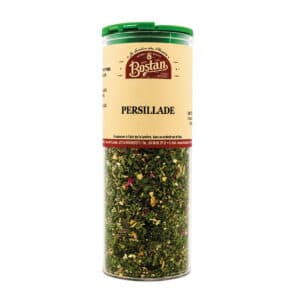 Tall transparent spice jar filled with persillade (dried parsley mix) and a green lid.