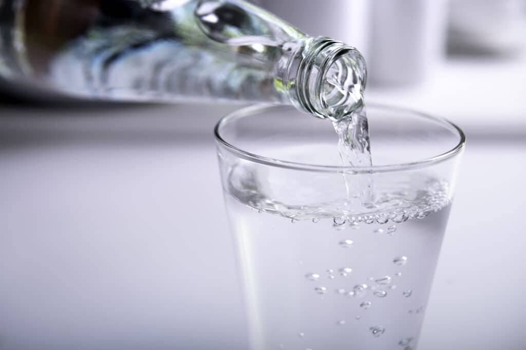 Bouteille en verre versant de l’eau dans un verre.