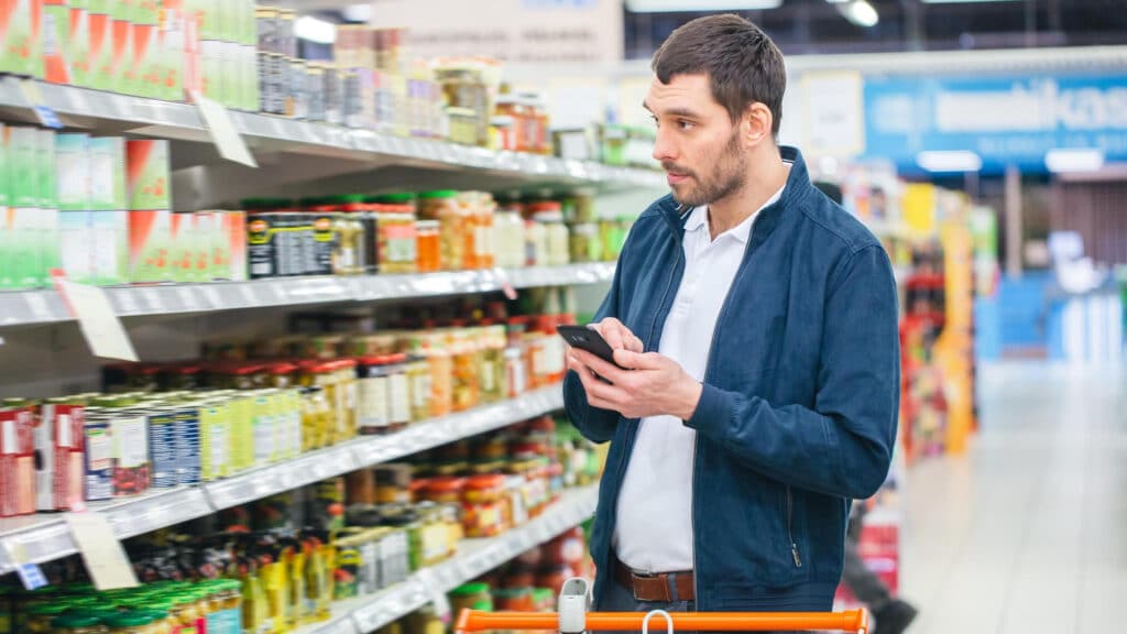 Homme faisant ses courses dans le rayon oriental d’un supermarché.