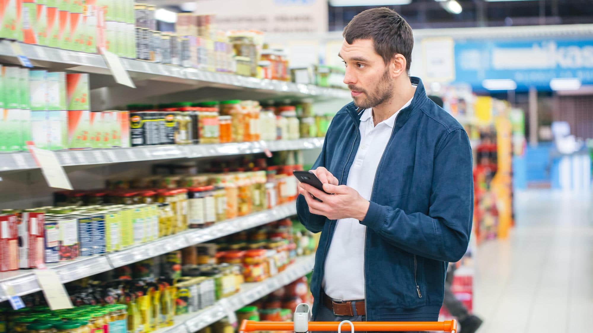 Homme faisant ses courses dans le rayon oriental d’un supermarché.